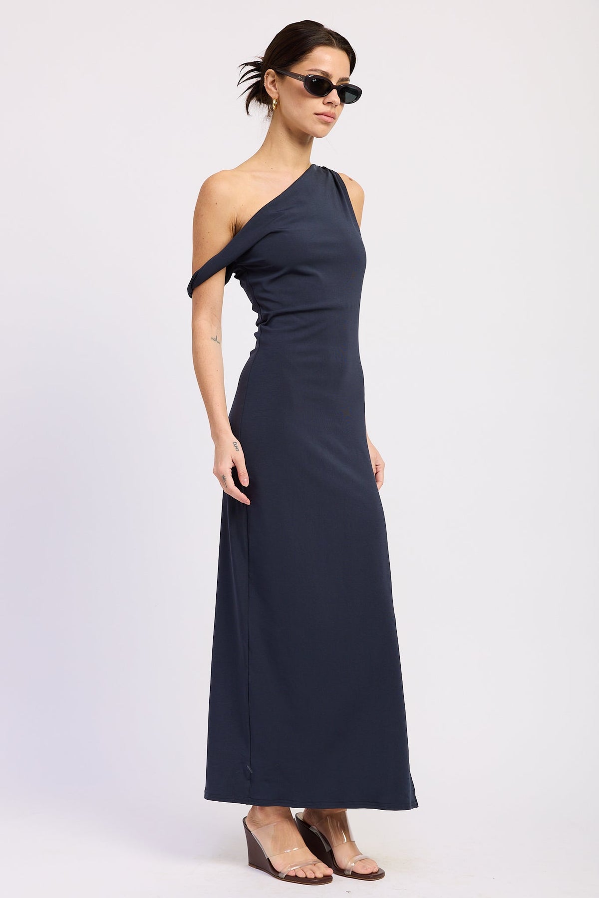 Navy one shoulder maxi dress with draped off shoulder detail and fitted silhouette, angled front view.