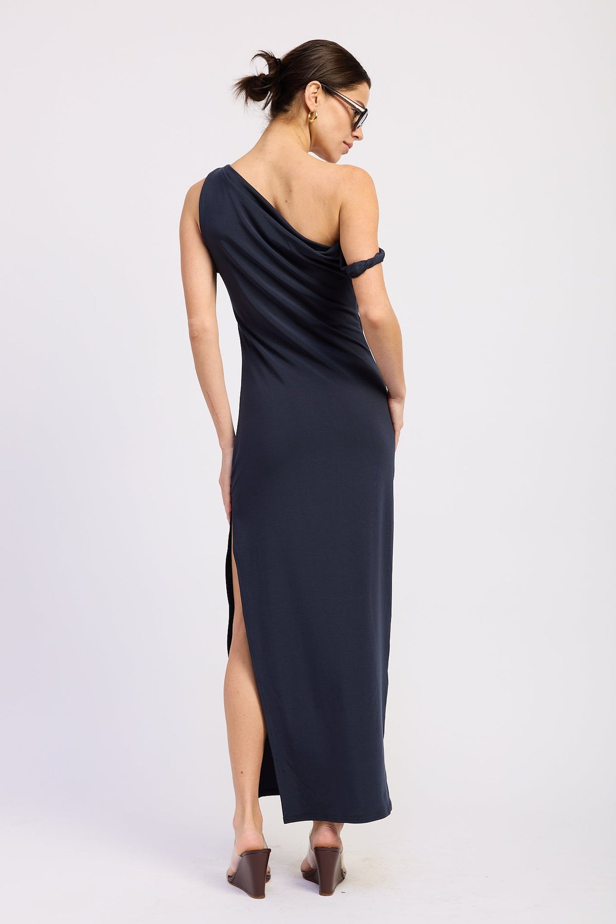 Navy one shoulder maxi dress with draped back neckline and high side slit, back view.