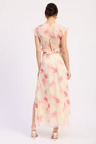 Back view of ivory and pink floral ruffle maxi dress with V neckline, flutter sleeves, waist cutouts and front slit
