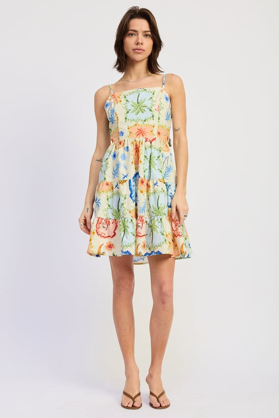 Woman wearing a scarf-inspired print blend of palm motifs and delicate detailing for a vibrant colorful floral tiered mini dress on a white background front view