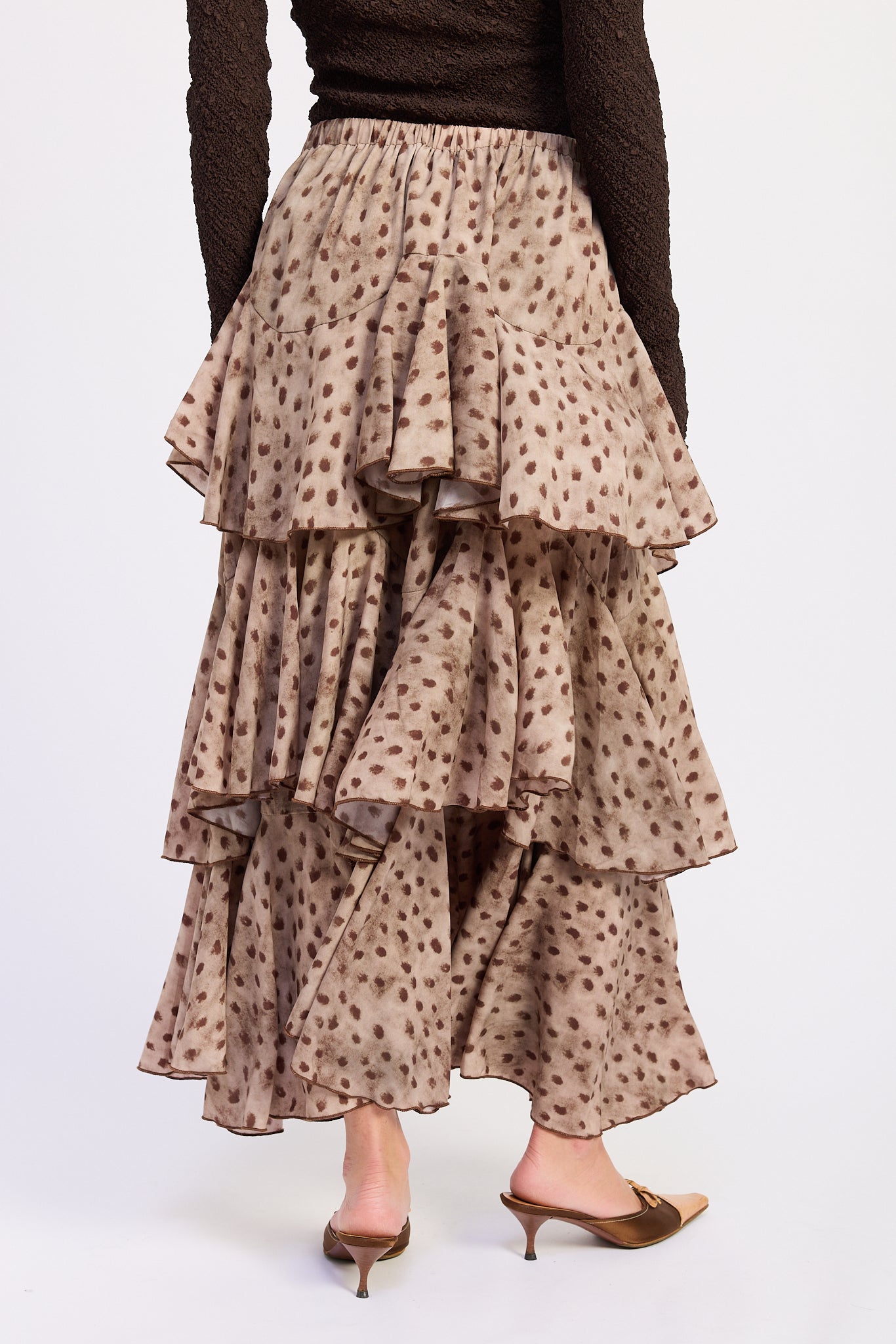 Back view of Sahara Spotted Ruffle Maxi Skirt with brown spotted print and tiered ruffle design.