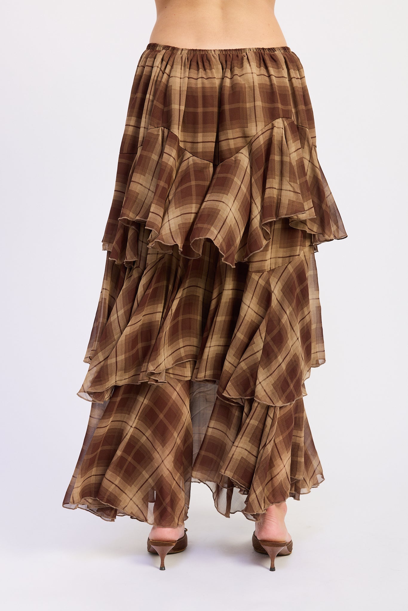 Back view of brown plaid chiffon maxi skirt featuring elastic waistband and multiple ruffle tiers.