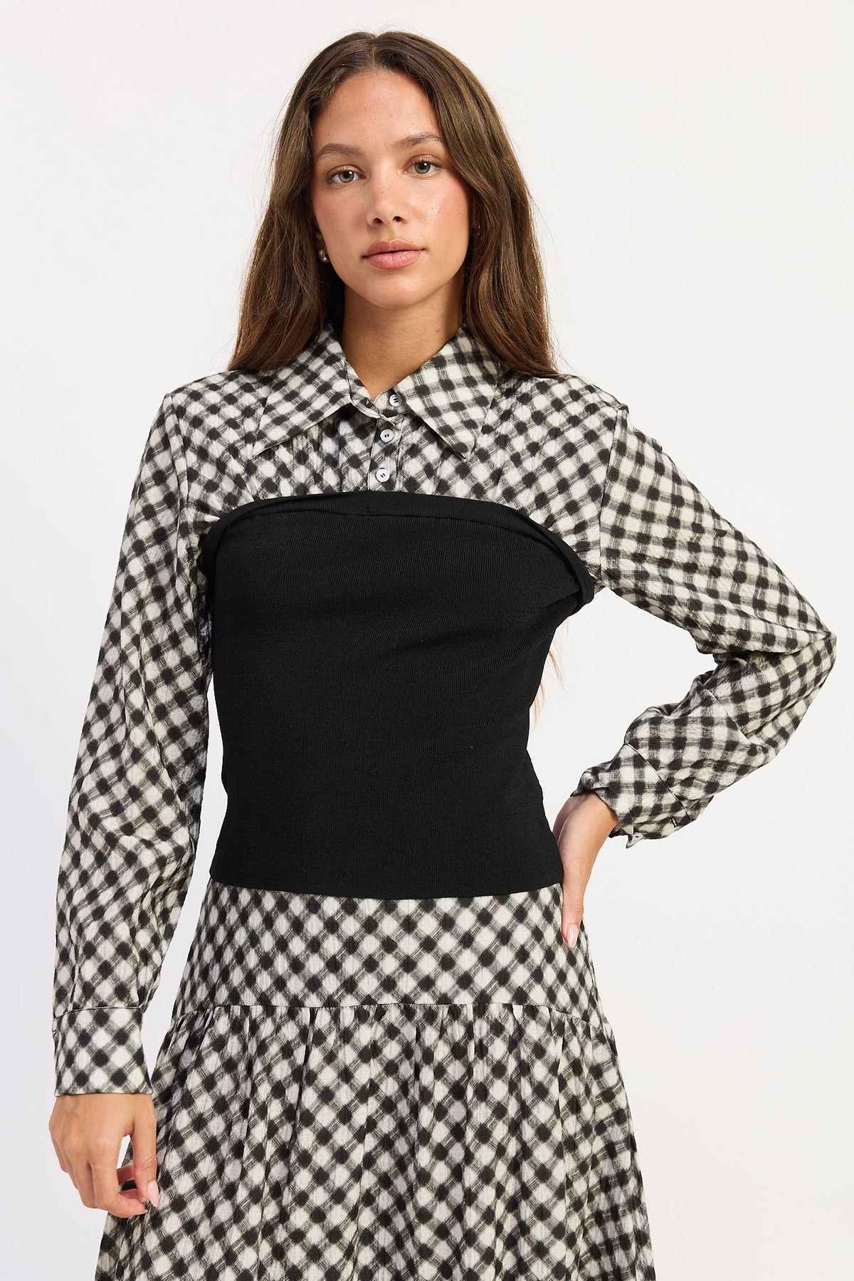 Thea black and ivory layered plaid collared top with fitted black contrast knit body, front view.