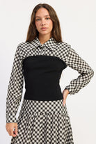 Thea black and ivory layered plaid collared top with fitted black contrast knit body, front view.