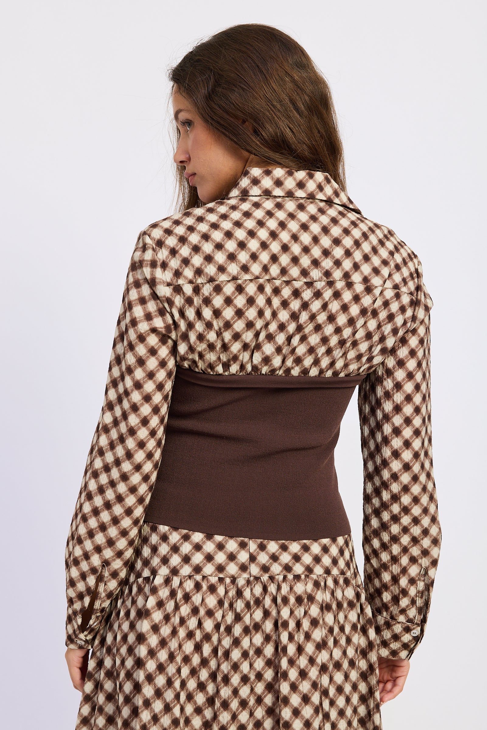 Back view of Thea espresso and ivory plaid top with fitted brown knit panel and collared shirt detail.