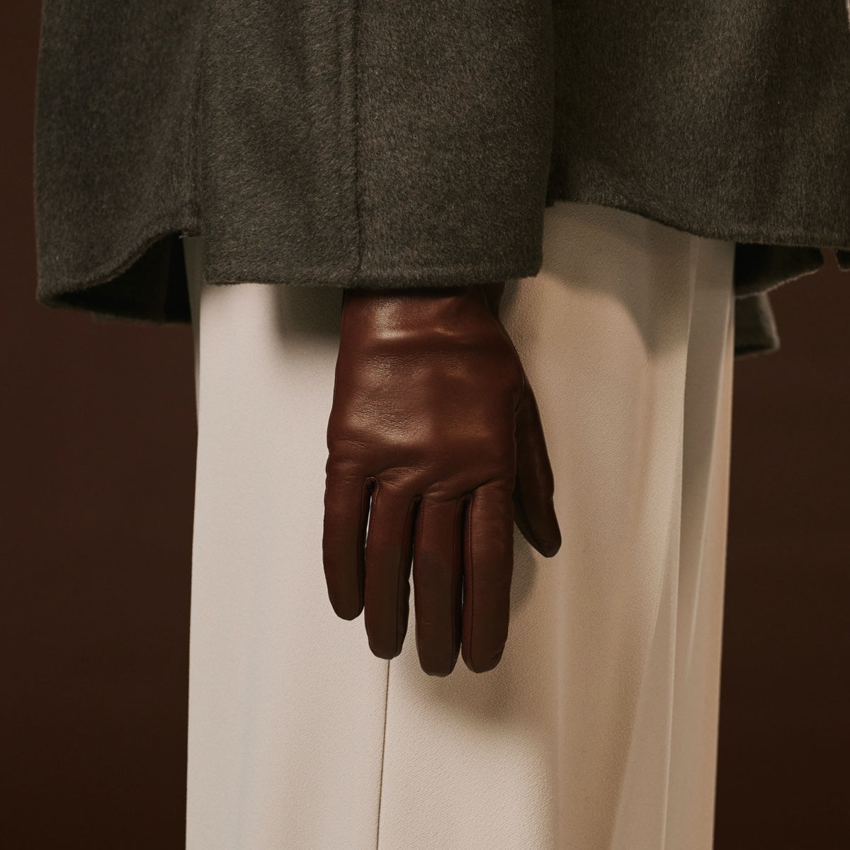 Brown leather glove on a neutral background