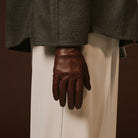 Brown leather glove on a neutral background
