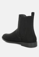 Black Chelsea boot on a light gray background