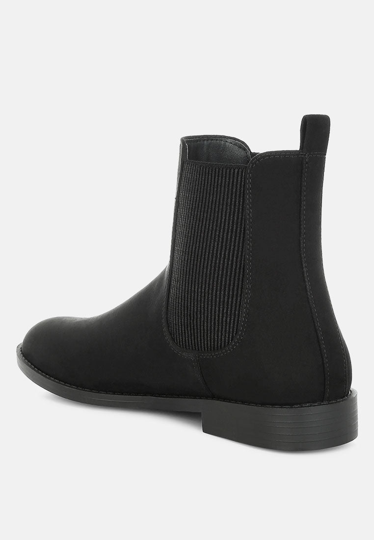 Black Chelsea boot on a light gray background