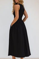 Black dress midi sleeveless dress worn by a model against a white background, back view.