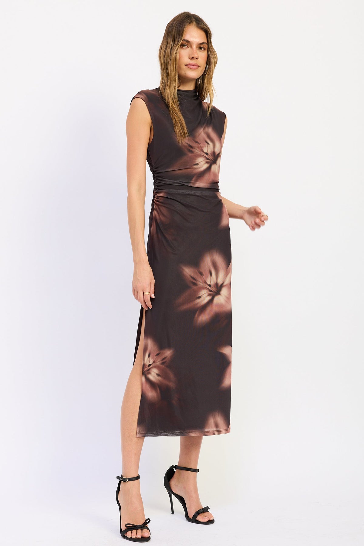 Side view of Ruched Midi Dress in chocolate brown with oversized flowers, sleeveless neckline and fitted silhouette.