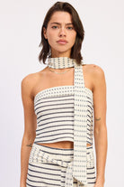 Woman wearing an ivory striped bandeau top with a scarf on a white background