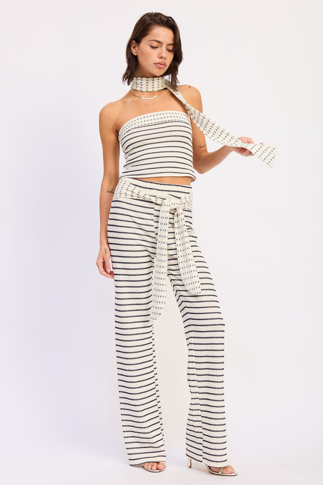 Woman wearing a black and white striped outfit on a white background