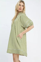 Side view of green stripe puff sleeve mini dress with front pocket detail, AVAH