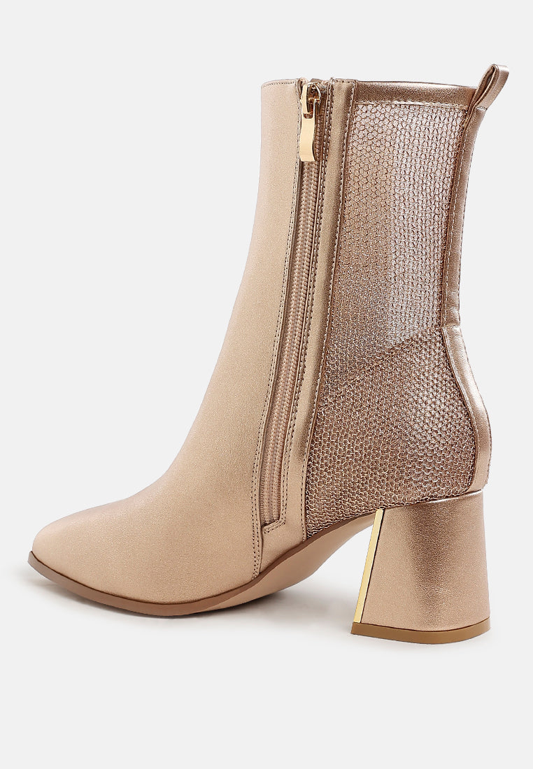 Gold ankle boot with gold zipper and heel on a white background