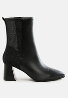 Black ankle boot with a block heel on a white background