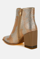 Gold embellished ankle boot with a block heel on a white background