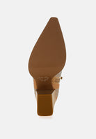 A close-up bottom view of a pointed-toe heeled shoe showing the brown textured outsole set against a light gray background.