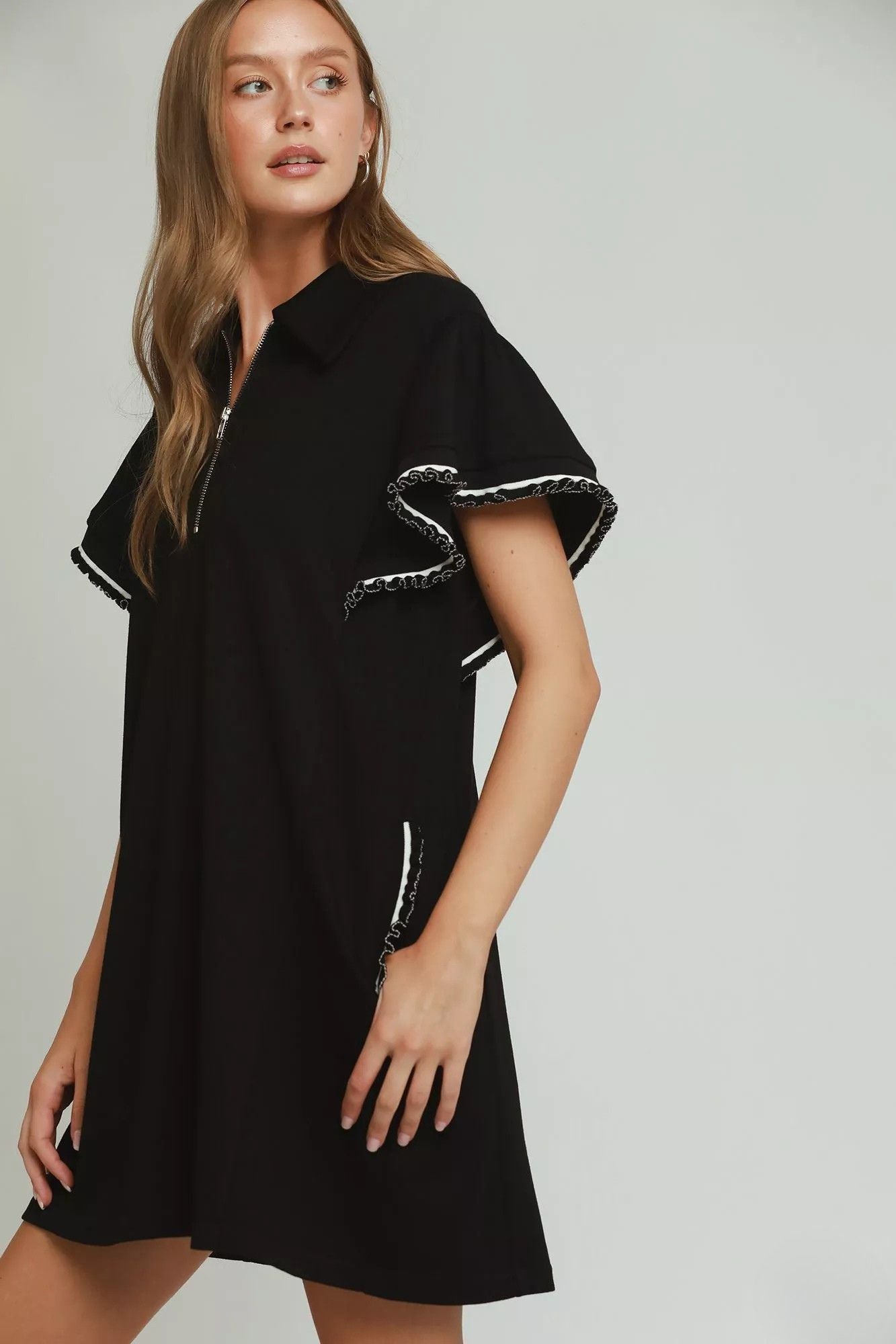 Side view of black flutter sleeve mini dress with contrast looped trim detail, AVAH