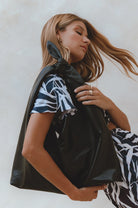 Low angle view of the Nudo Knotted Leather Shoulder Bag in black genuine leather featuring the oversized silhouette and signature knotted handle.