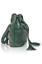 Blue leather woven backpack/handbag with braded drawstring opening and braided adjustable straps with brass hardware on the front on white background, side view