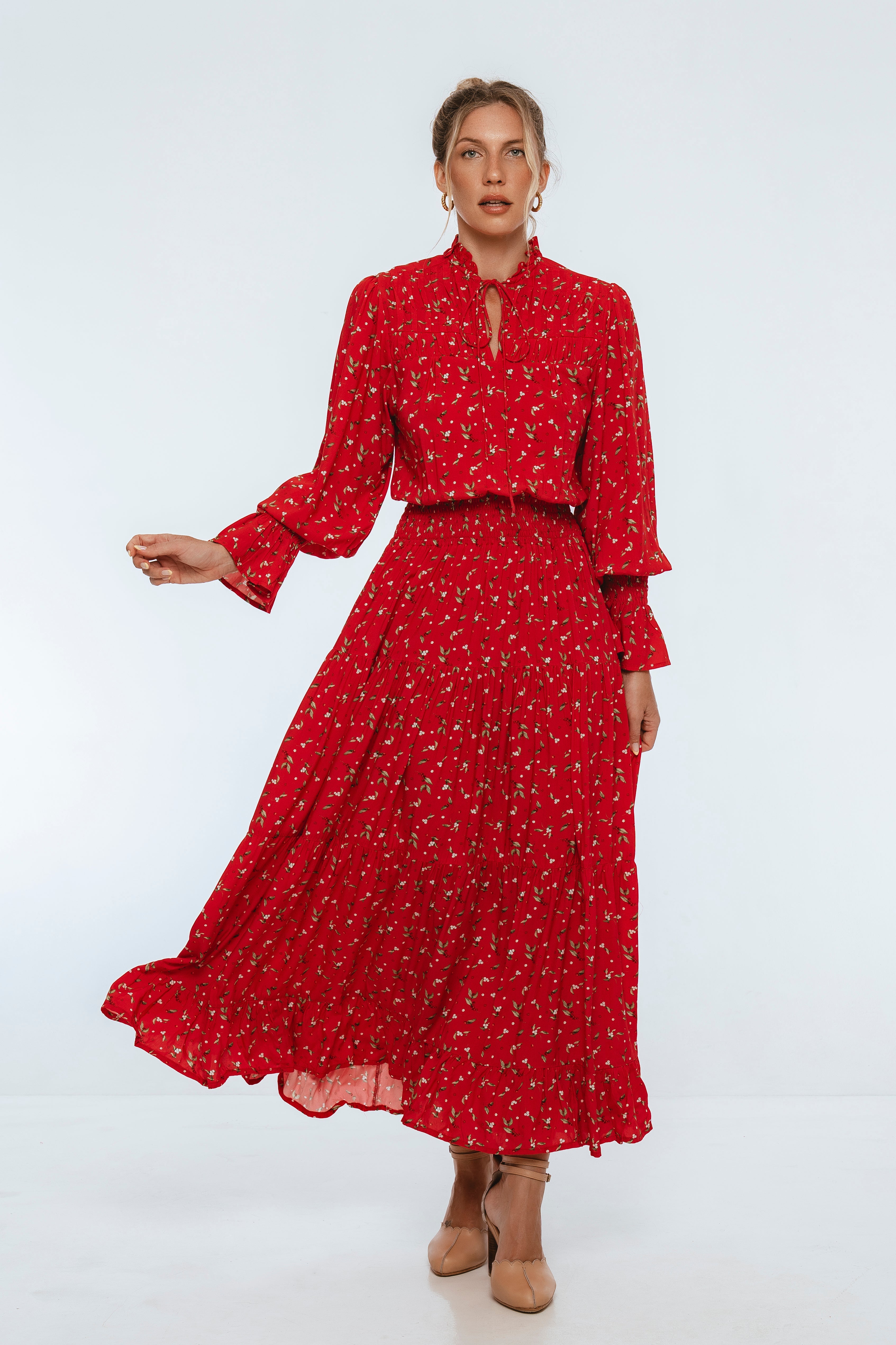 Woman wearing a red dress with a floral pattern on a white background