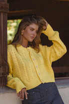 Woman wearing a yellow knitted cardigan outdoors