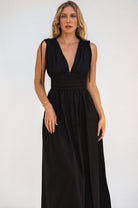 Woman wearing a black cotton sleeveless maxi dress against a white background