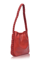 Side profile of the Sivuple Leather Shoulder Bag in vintage red showcasing the braided leather shoulder strap and slim bucket design.