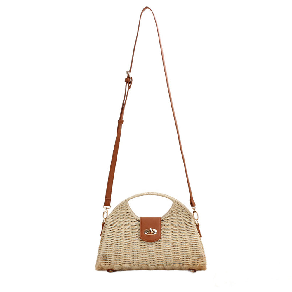 Straw crossbody bag with vegan leather and fixed top handle and removable crossbody strap complete with a fold over clasp and gold hardware, in straw front view