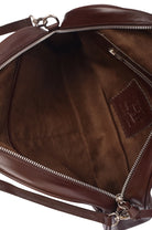 Closeup of suede lined interior of brown leather bag with visible stitching and a brand logo on a white background