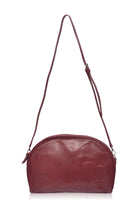 Red leather handbag with an adjustable crossbody strap on a white background front view