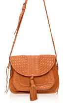 Tan vintage leather woven handbag with a tassel and long adjustable strap on a white background