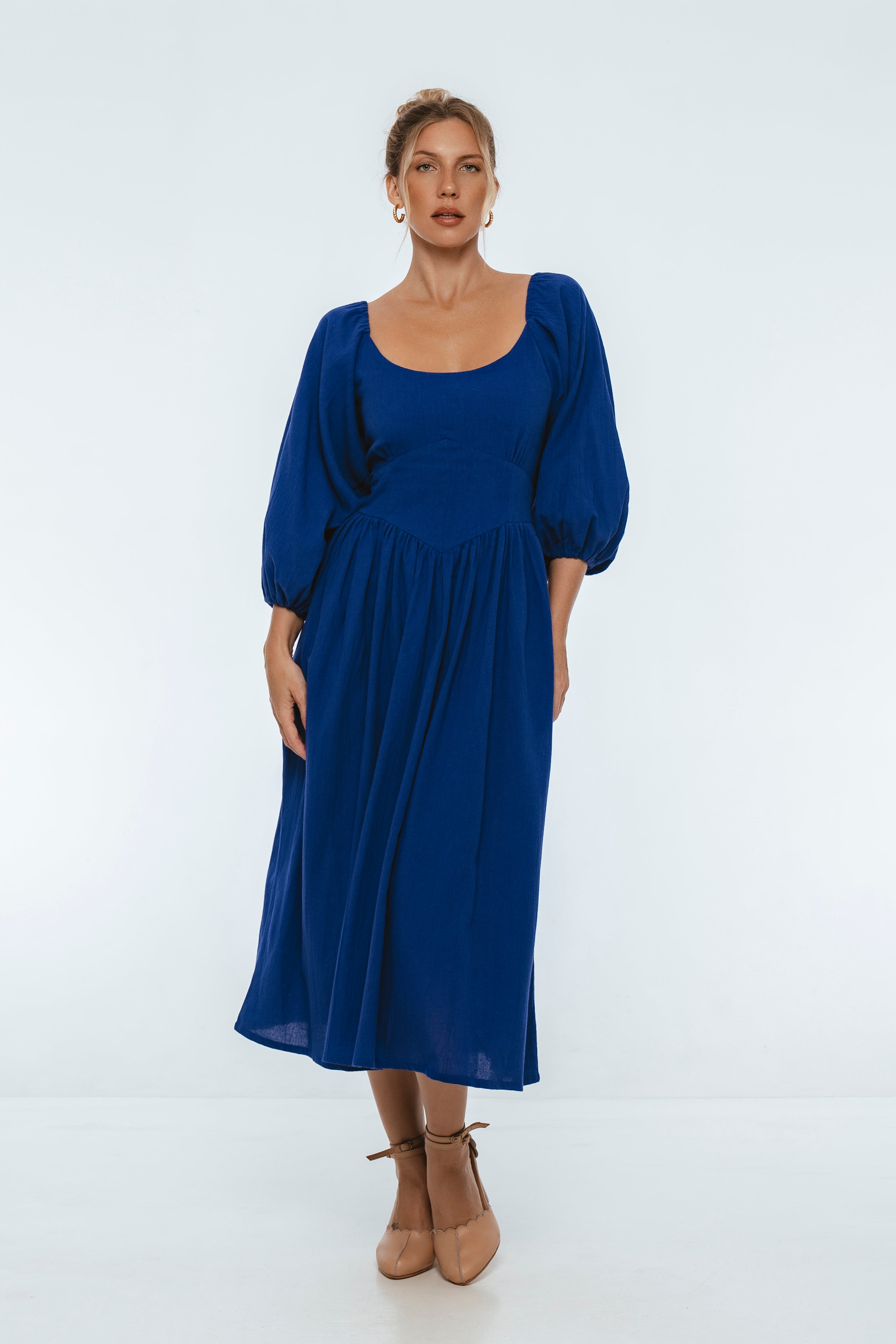 Woman wearing a blue midi dress on a white background