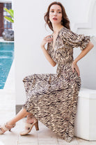 Woman wearing a beige patterned midi dress by a poolside