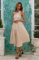 Woman wearing cream floral one-shoulder dress with a fitted bodice, smocked at the bust, midi length, front view