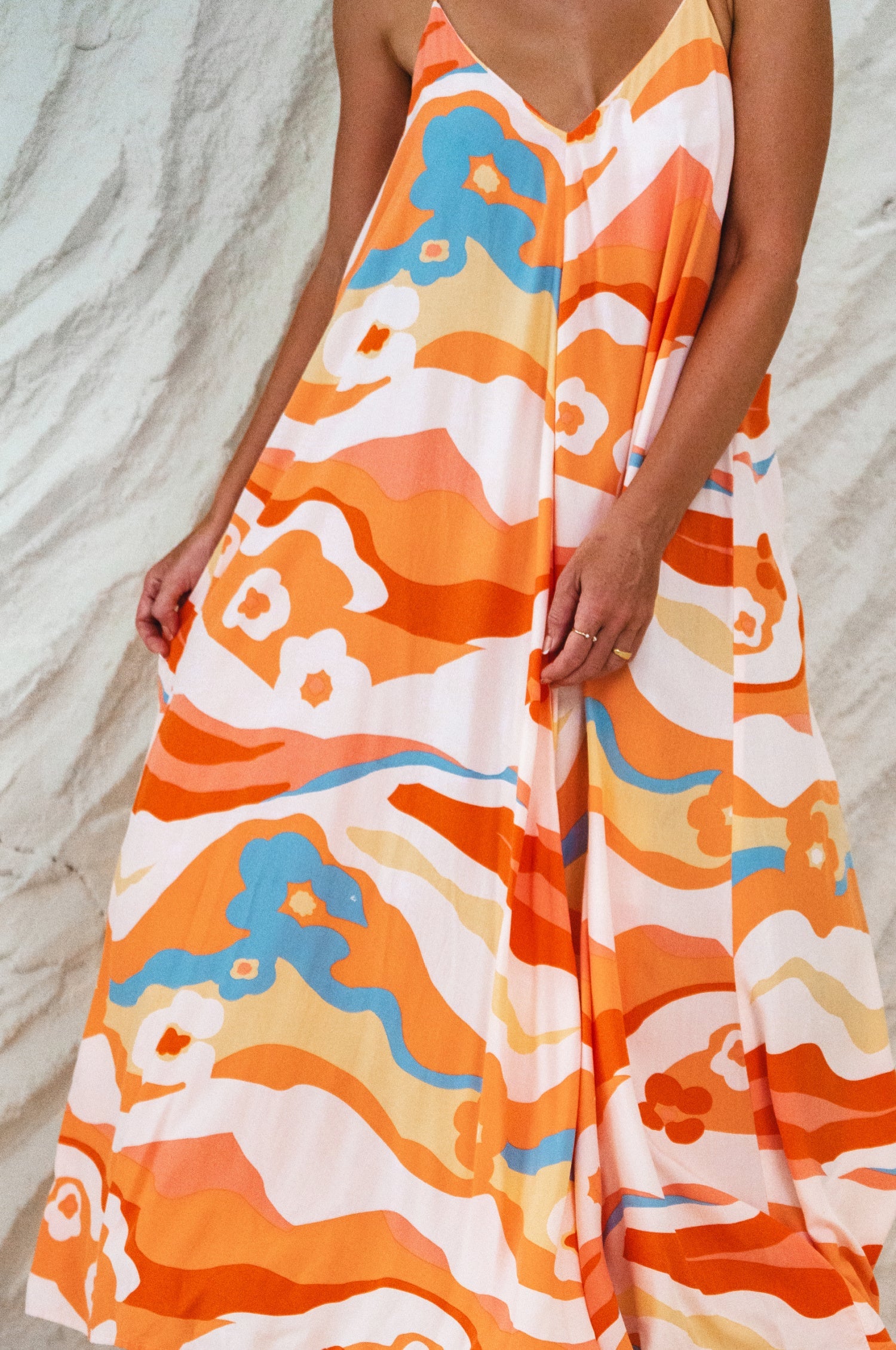 Orange and white patterned dress on a sandy background