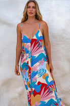 Woman wearing a colorful patterned dress against a white background