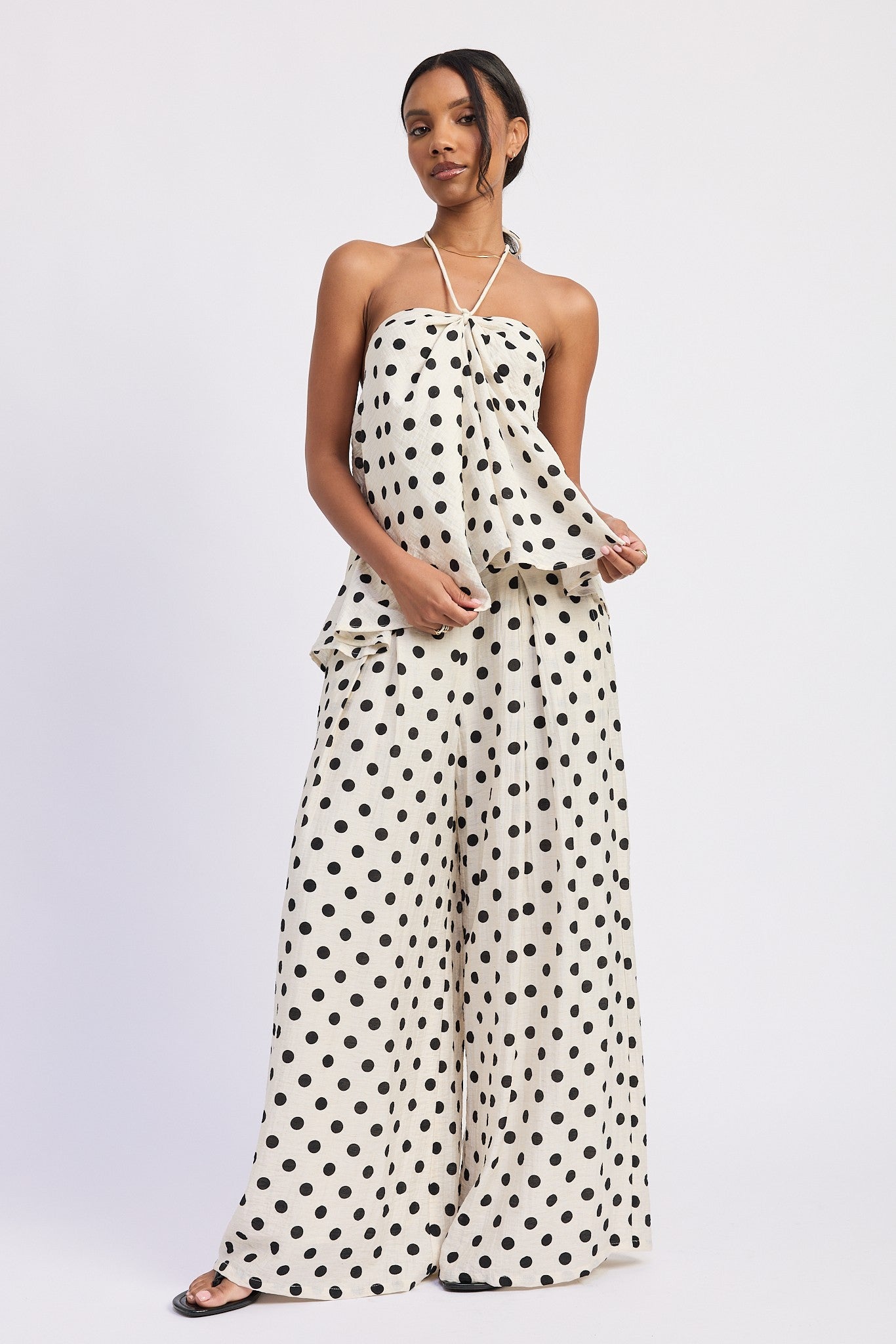 Ivory polka dot halter top styled with matching pants, movement detail
