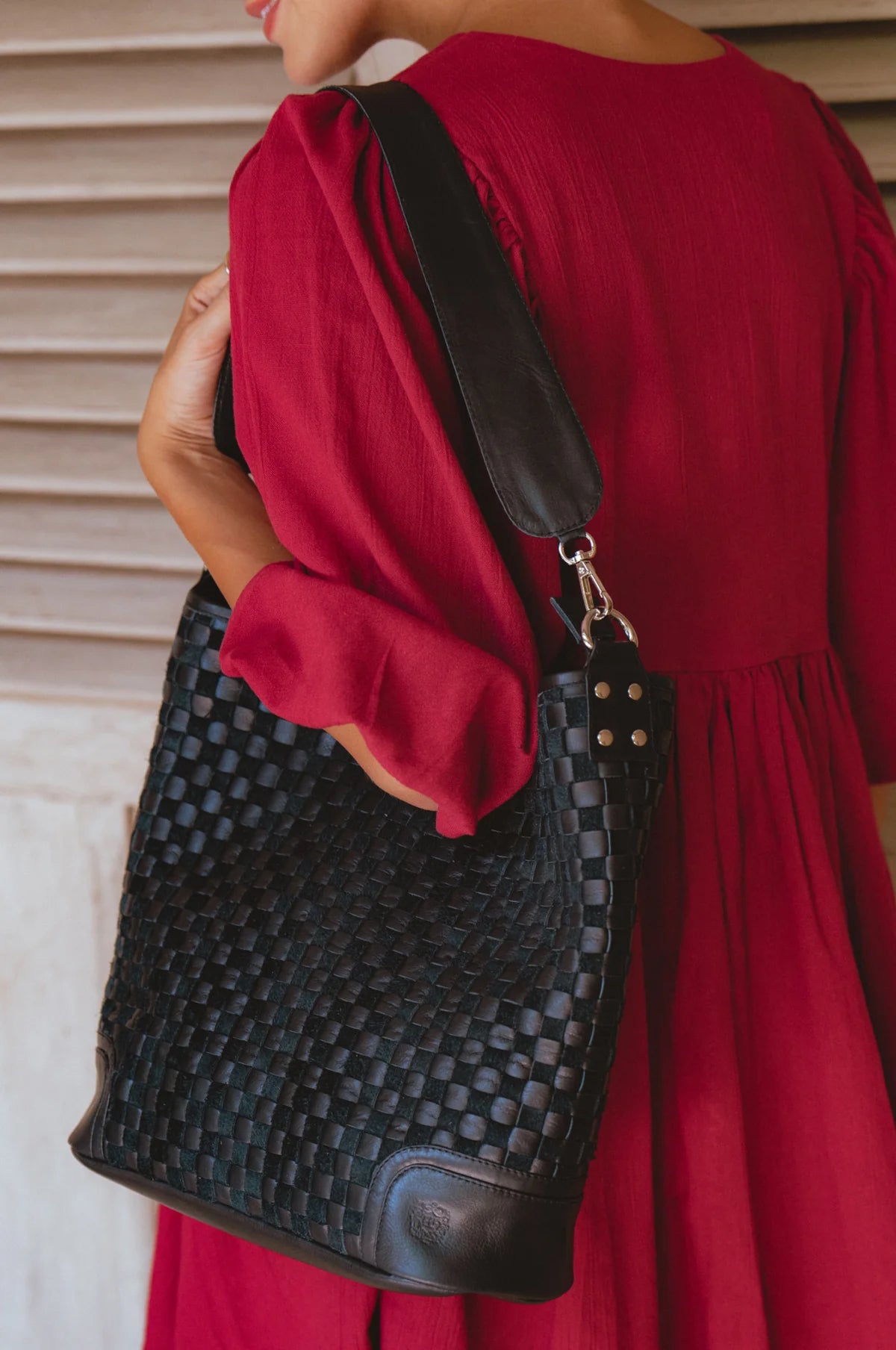 Model carrying the Soho Lane Woven Leather Shoulder Bag in black handcrafted genuine leather
