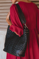 Model carrying the Soho Lane Woven Leather Shoulder Bag in black handcrafted genuine leather
