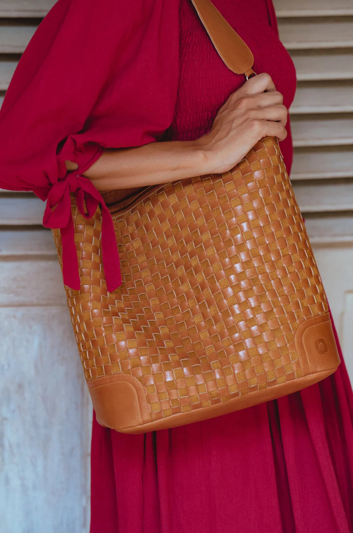 Model carrying the Soho Lane Woven Leather Shoulder Bag in camel with a handwoven genuine leather design and shoulder strap.