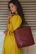 Model wearing the Soho Lane Woven Leather Shoulder Bag in maroon handcrafted genuine leather
