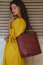 Model wearing the Soho Lane Woven Leather Shoulder Bag in maroon handcrafted genuine leather
