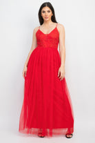 Model wearing a red evening gown against a white background