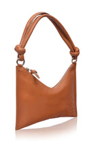 Tan leather handbag with gold hardware and knotted leather handle white background