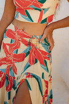 Person wearing a colorful floral two-piece outfit with a neutral background