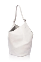 A minimalist white leather shoulder bag with a single strap and a slouchy, asymmetrical silhouette, shown on a clean white background.
