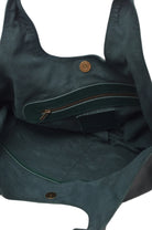 Closeup of the green suede lined geen leather bag with a zipper pocket on a white background