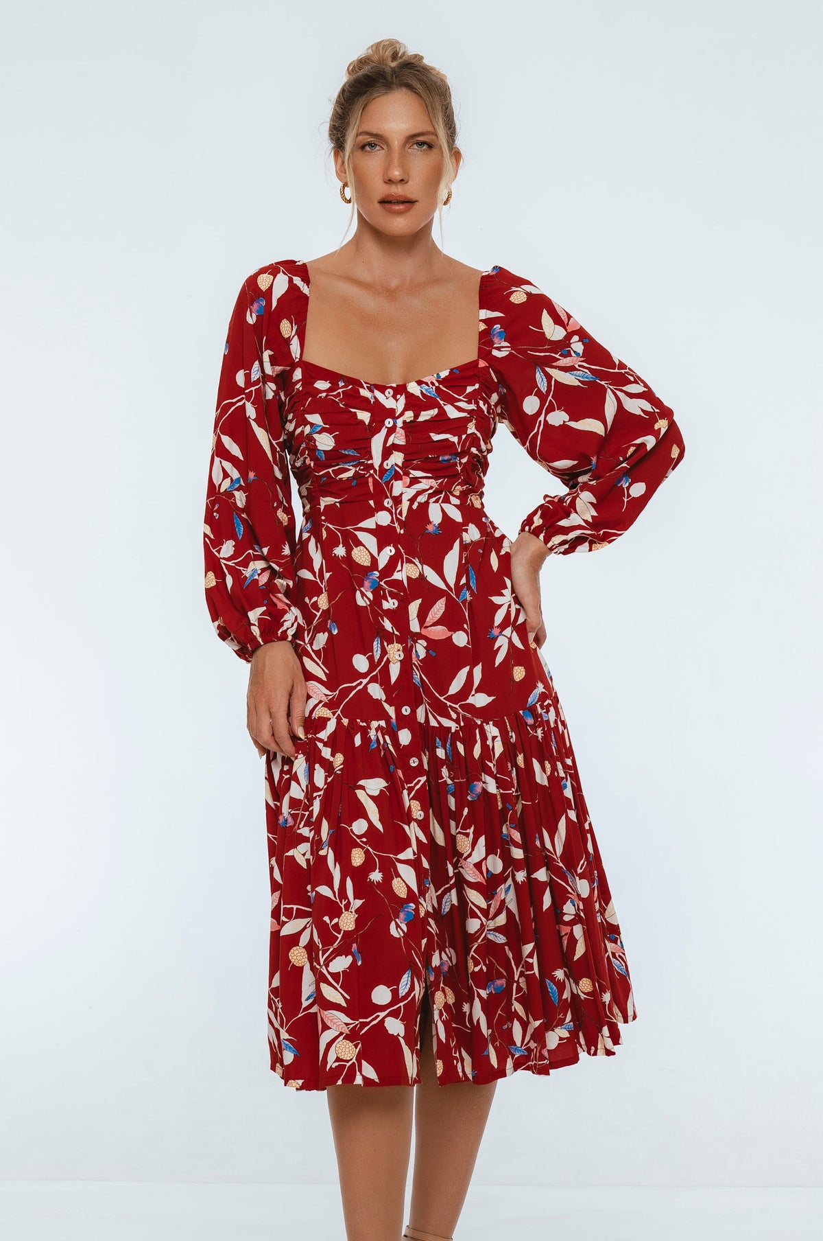 Woman wearing a red floral dress on a white background